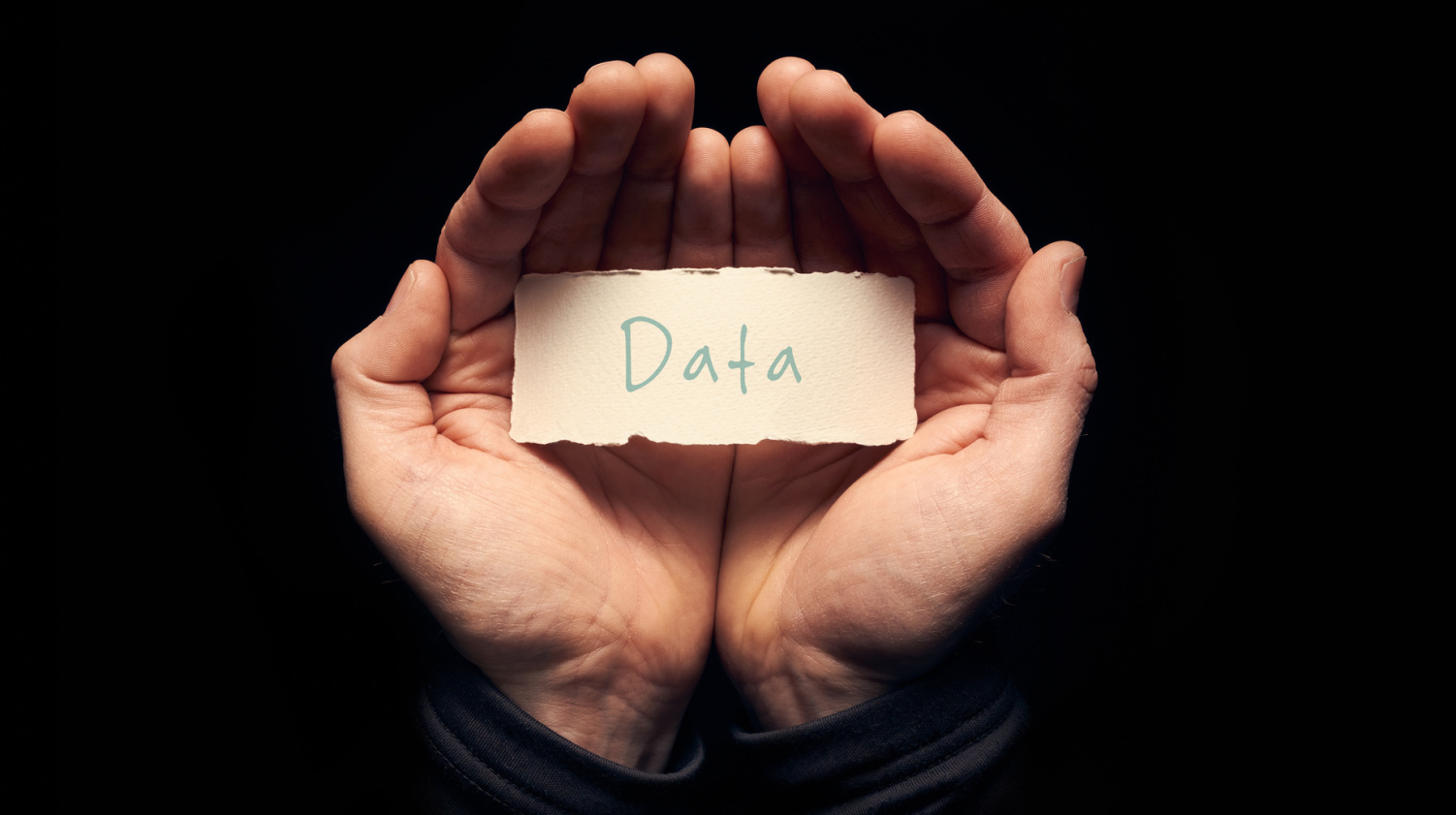 Hände, die einen Zettel mit der Aufschrift "Data" (Daten) halten; Aaden Detektei Berlin