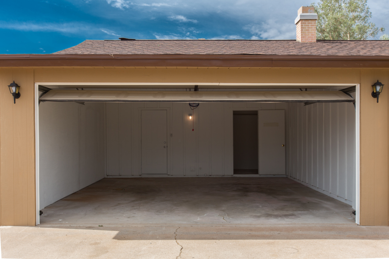 Leere Garage, Garagentor steht offen, Sonnenschein, Garage gehört zu einem Einfamilienhaus. Aaden Wirtschaftsdetektei GmbH Berlin